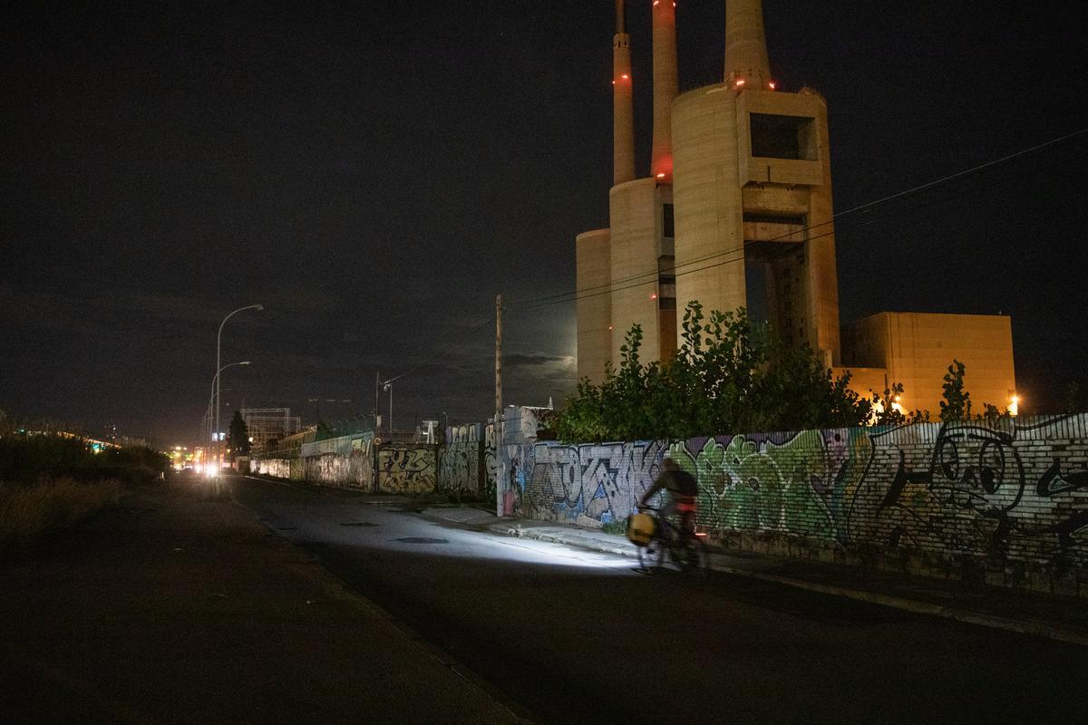 Un ciclista circula por el tramo sin luz a raíz de un robo de cable junto a las Tres Xemeneies, entre Sant Adrià de Besòs y Badalona.