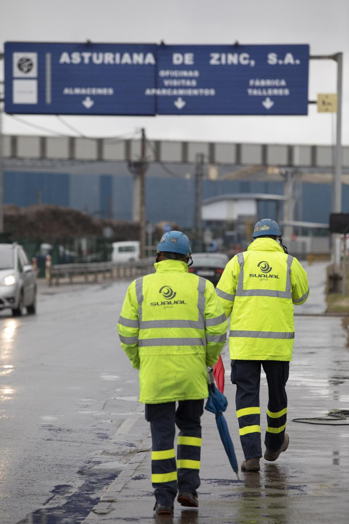 Dos trabajadores en el acceso a Asturiana de Zinc.