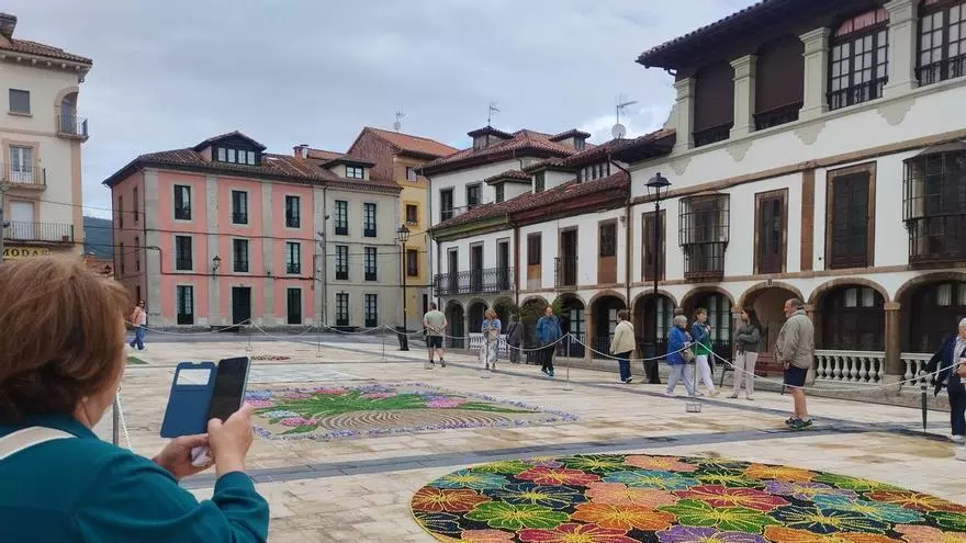 Pravia desafía a la lluvia y sale en procesión con el Santísimo sobre las alfombras florales y de sal: "Es el año que más guapas quedaron"