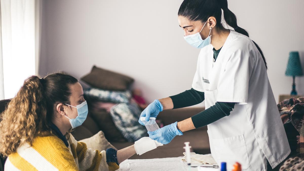 Una mujer sanitaria atiende a una paciente.