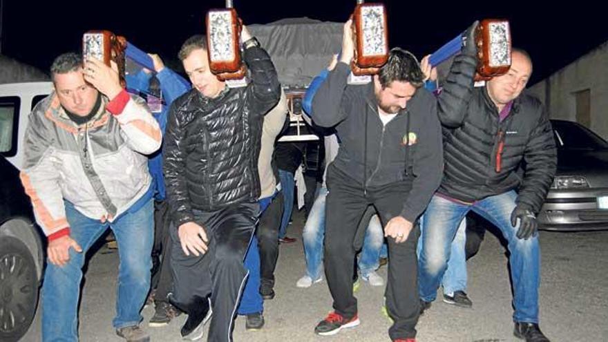 Los costaleros del Sant Crist se preparan para levantar el trono al toque de campana.