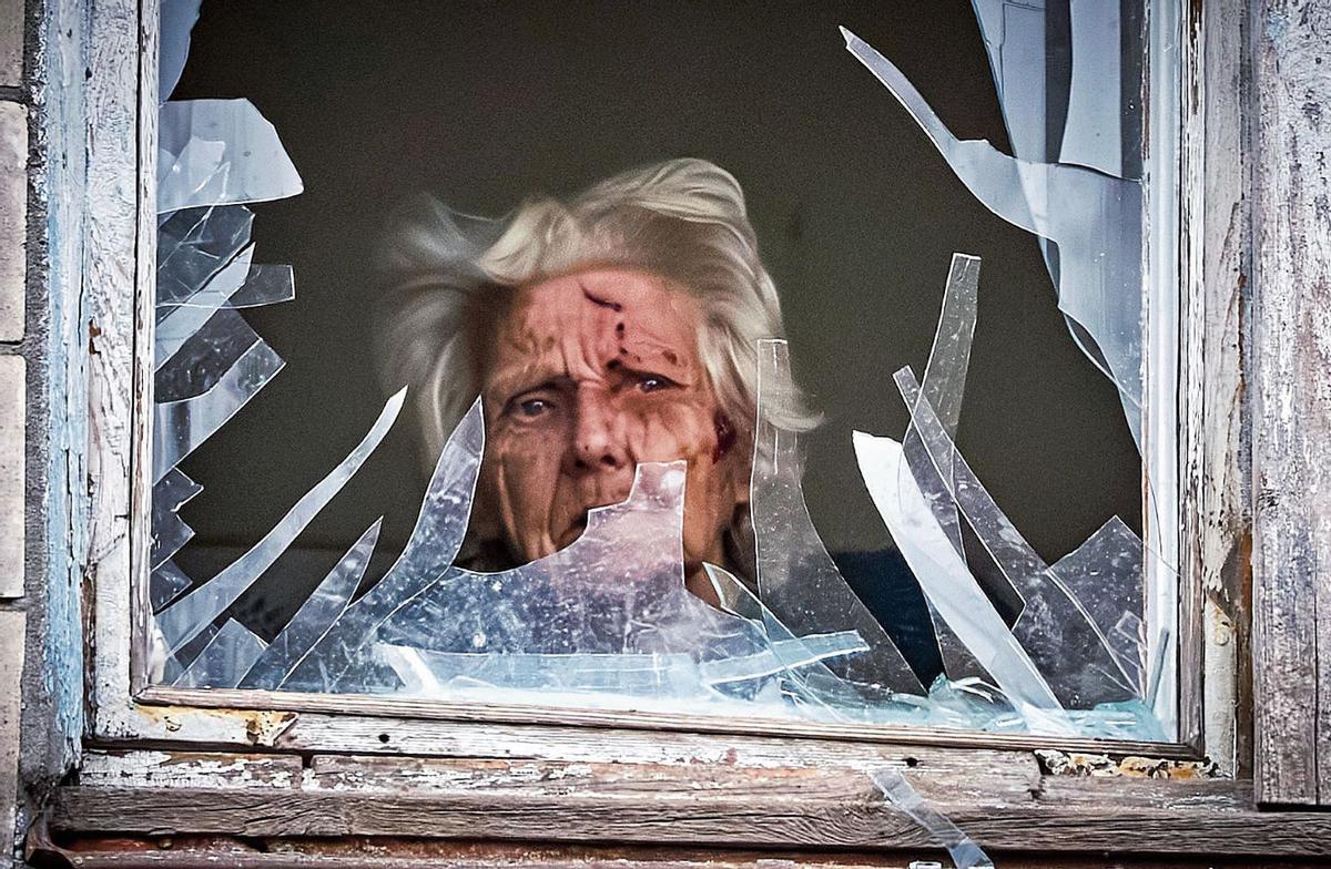 Una anciana herida mira a través de una ventana de su casa de Kiev tras un bombardeo ruso, el pasado 23 de diciembre.