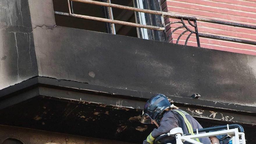 Los bomberos, ayer, en la vivienda donde se produjo el incendio.