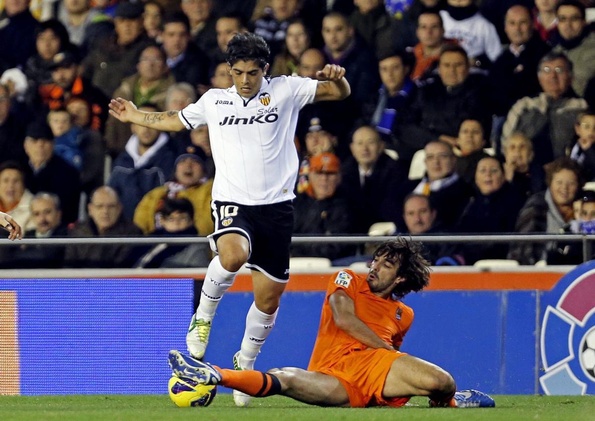 GRA167. VALENCIA, 01/12/2012.- El centrocampista argentino del Valencia CF Ever Banega (i), pelea un balón con el defensa de la Real Sociedad Carlos Martínez, en partido correspondiente a la decimocuarta jornada de Liga en Primera División disputado esta tarde en el estadio de Mestalla. EFE/Manuel Bruque. ever banega - carlos martinez. valencia - real sociedad. liga españa 2012/2013 valencia - real sociedad. deportiva accion 2012/2013 camiseta naranja. mestalla
