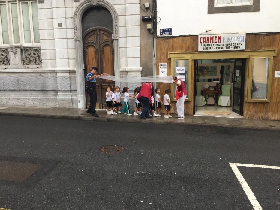 Niños protegiéndose de la lluvia en la calle Malteses.