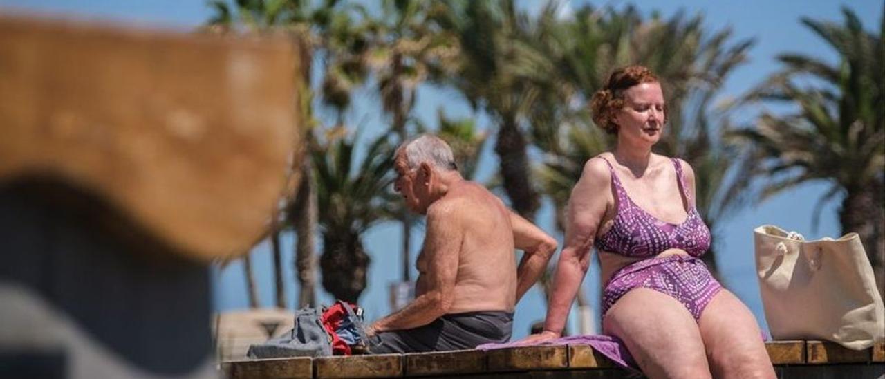 Dos turistas tomando el sol.