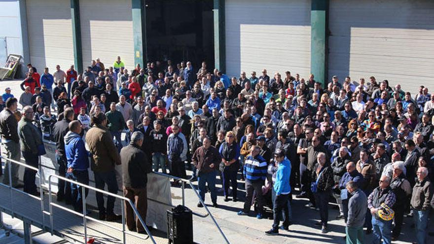 Los trabajadores que fueron a la asamblea, escuchan al comité de empresa.