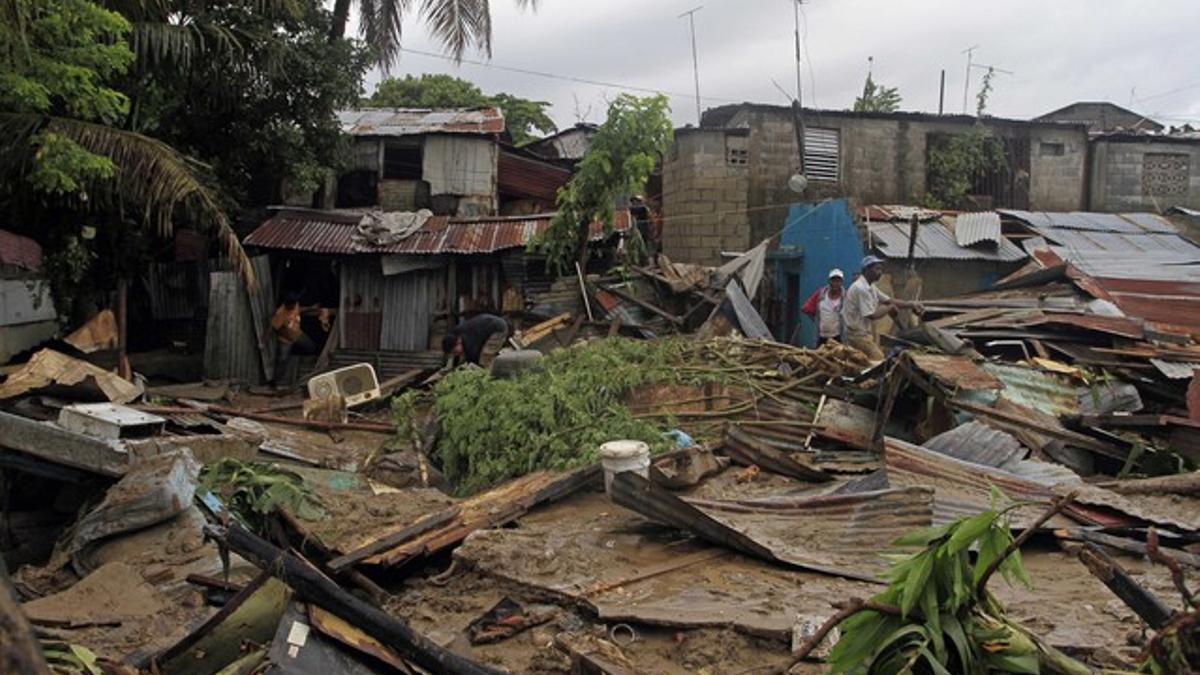 Vecinos de San Cristóbal buscan entre los escombros de sus casa, tras el paso del huracán 'Irene' por República Dominicana', el miércoles.