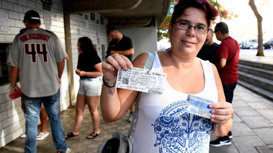 Una abonada muestra la entrada para el derbi.