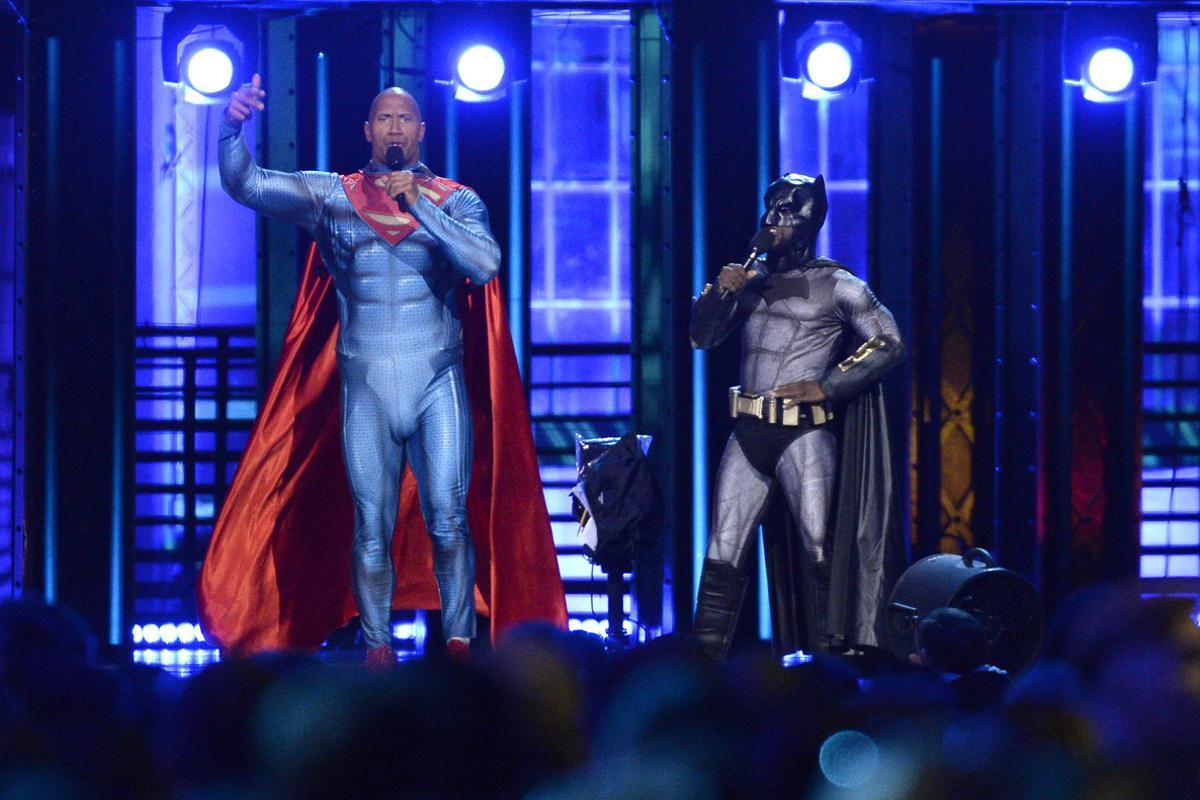 Kevin Hart, dressed as Batman, and Dwayne Johnson, dressed as Superman, speak at the MTV Movie Awards at Warner Bros. Studio on Saturday, April 9, 2016, in Burbank, Calif. (Kevork Djansezian/Pool Photo via AP)