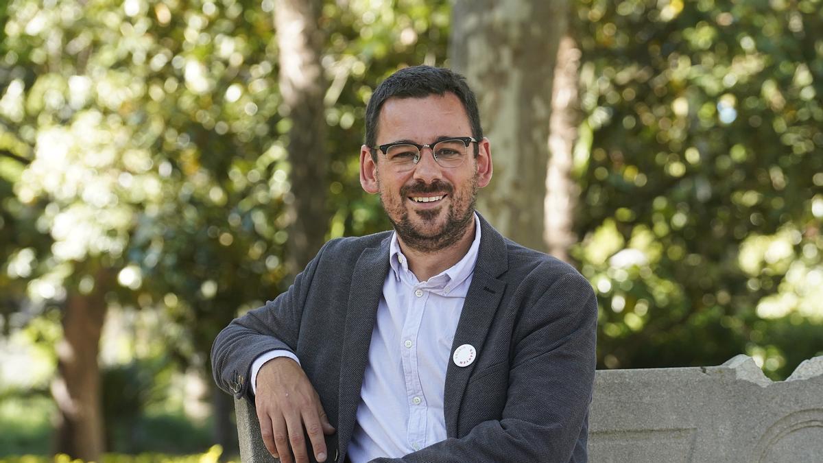 El candidat de Guanyem Girona, Lluc Salellas, assegut a un banc del parc de la Devesa.