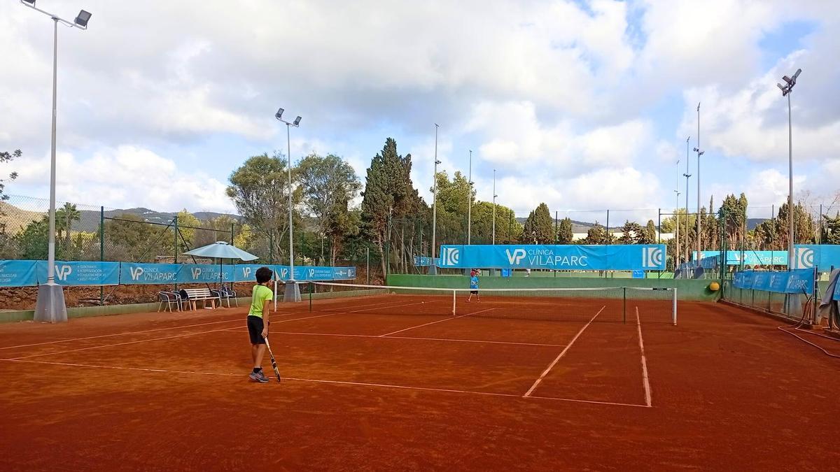 Dos jóvenes disputan un partido de tenis.