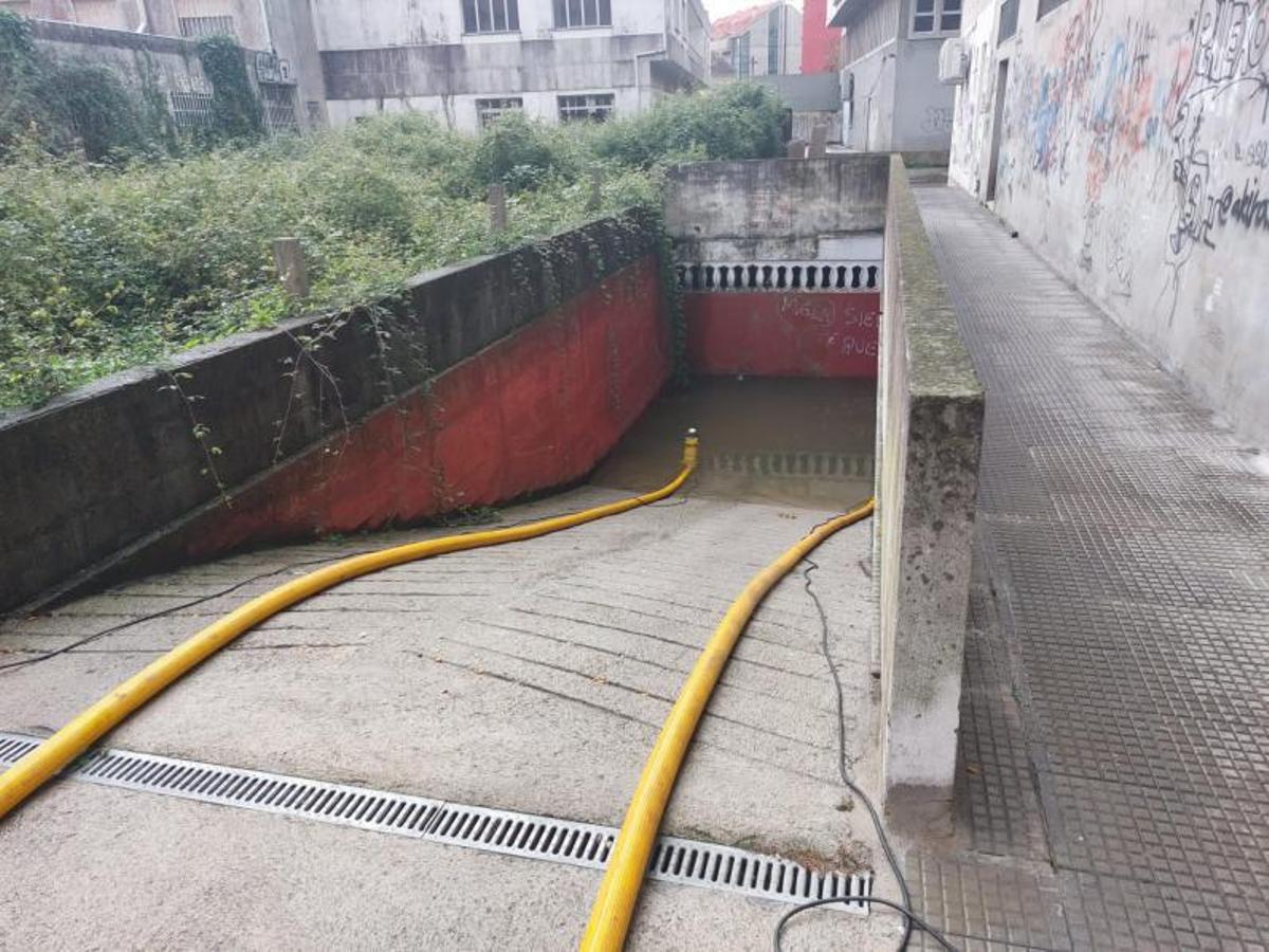 Uno de los bomberos que intervino ayer para evacuar el agua del edificio cangués. |   // S.A.