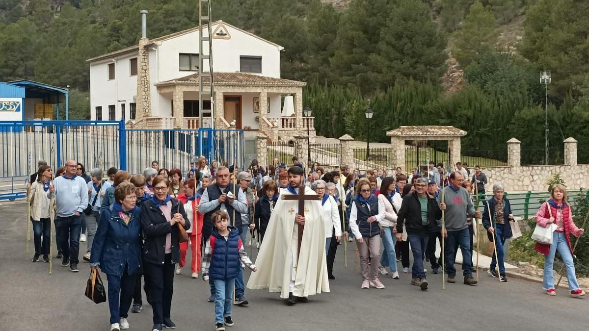 Numerosos vecinos acompañan al párroco en la subida a la ermita.