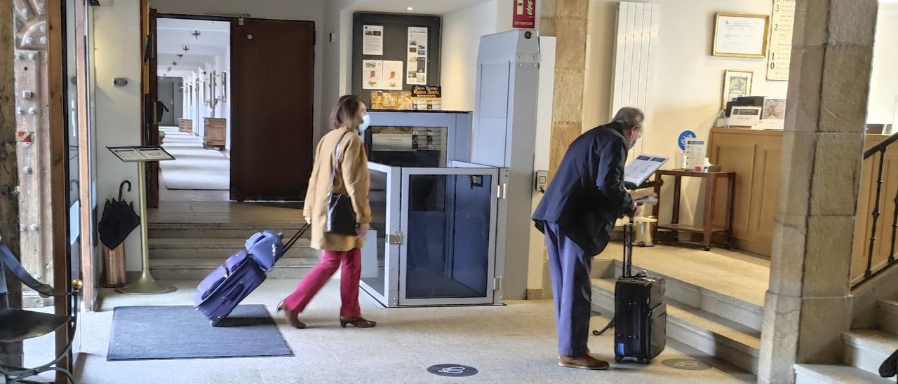 Dos personas acceden a la zona de recepción del Parador Nacional de Turismo Fernando II.