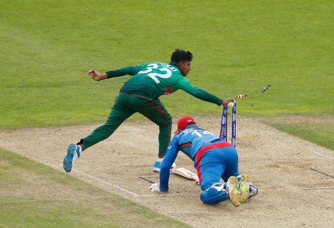 Mosaddek Hossain (L) de Bangladesh intenta atropellar al capitán de Afganistán, Gulbadin Naib, durante el partido de la fase de grupos de la Copa Mundial de Críquet 2019 entre Bangladesh y Afganistán en el Rose Bowl en Southampton, sur de Inglaterra.