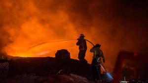 Los bomberos luchan por extinguir el incendio en una zona comercial de San Cristóbal, en República Dominicana.