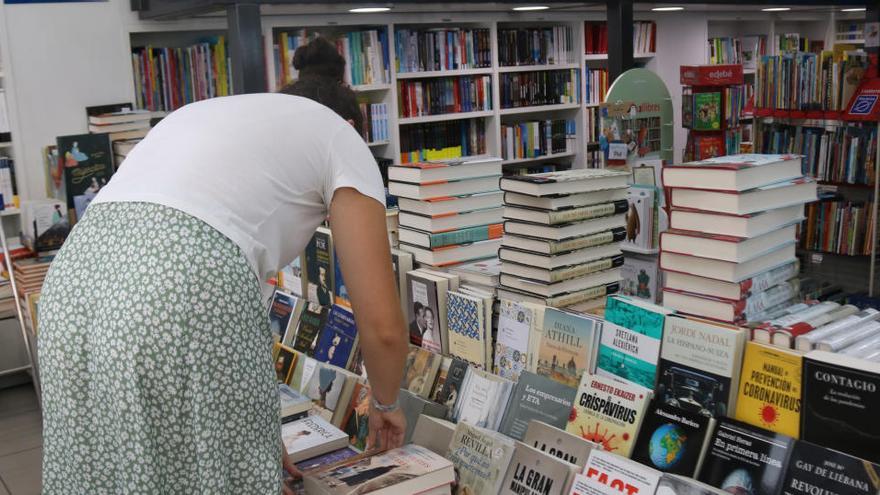 Una jove repassant alguns llibres en un establiment a Girona |