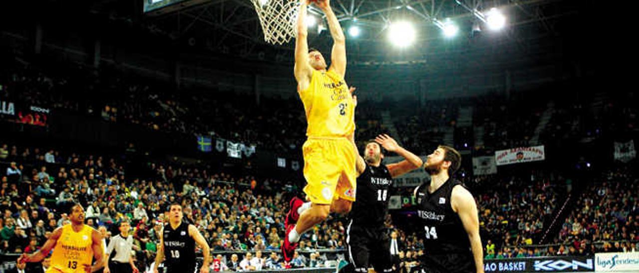 El ala-pívot Ian O&#039;Leary culmina un espectacular &#039;alley oop&#039; a pase del base Albert Oliver ante la mirada del Bilbao Basket.