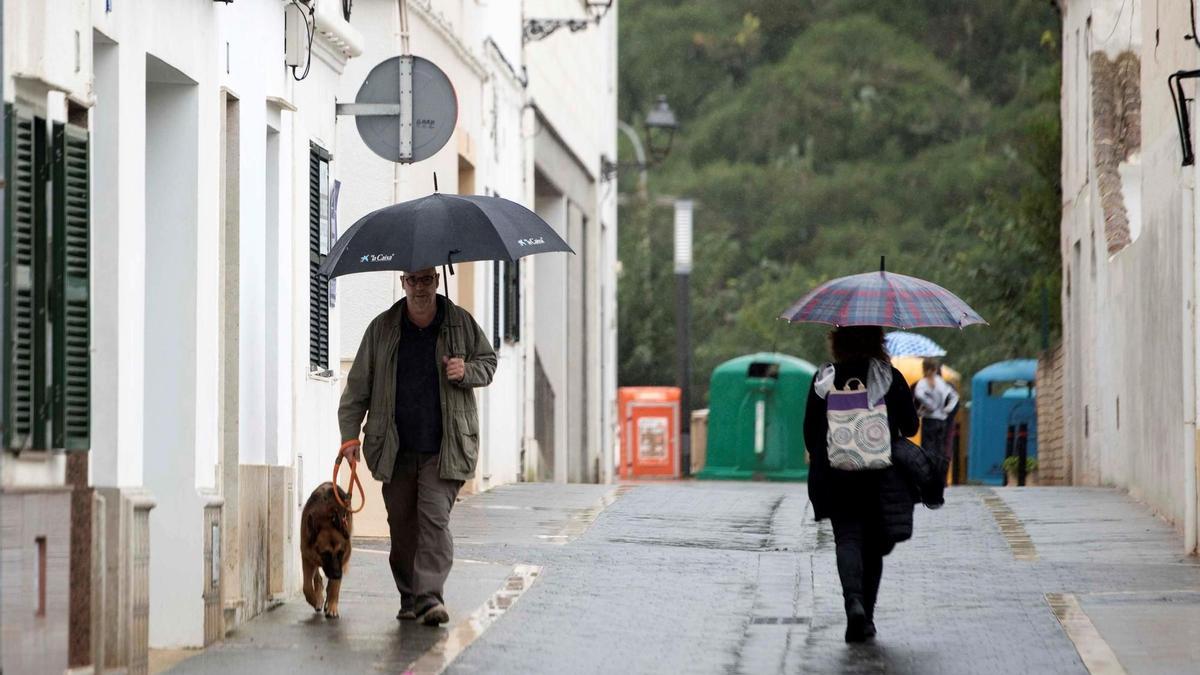 Peatones se refugian bajo sus paraguas en Menorca, este sábado. EFE/ David Arquimbau Sintes