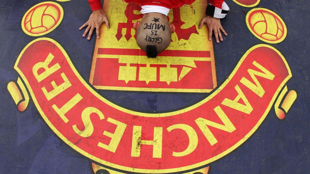 Un aficionado besando el escudo del Manchester United