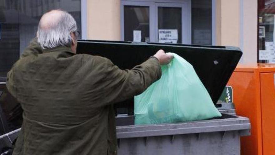 Un vecino deposita una bolsa de basura en un contenedor de la capital.