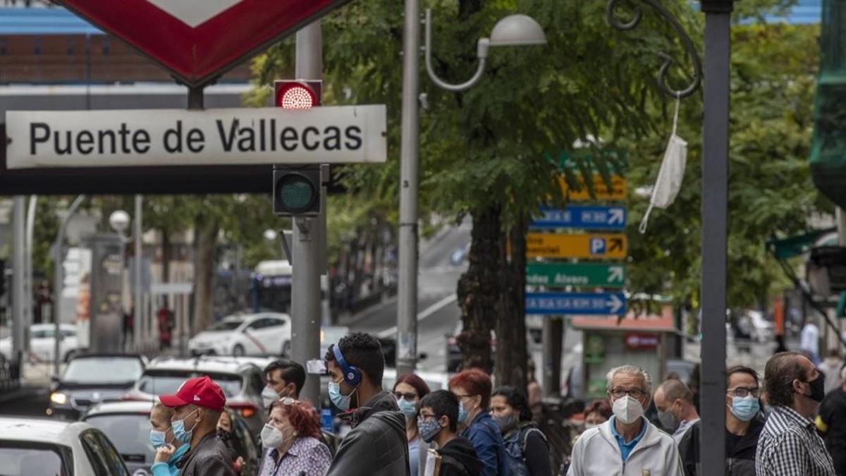 Peatones ante el metro de Puente de Vallecas, en Madrid.