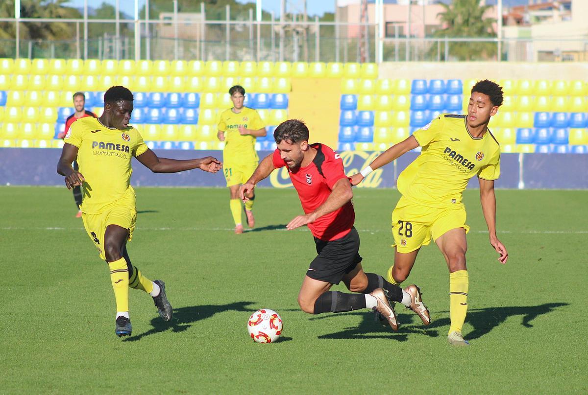 Viqué y César Bonafé intantan frenar al futbolista de La Nucía David Velazquez.