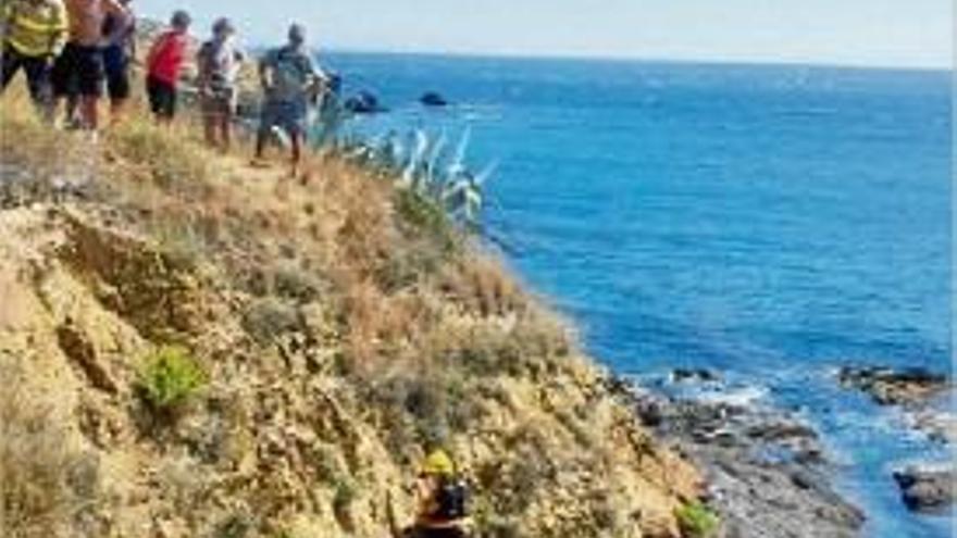 Una bombera, despenjant-se per les roques per arribar al nen.