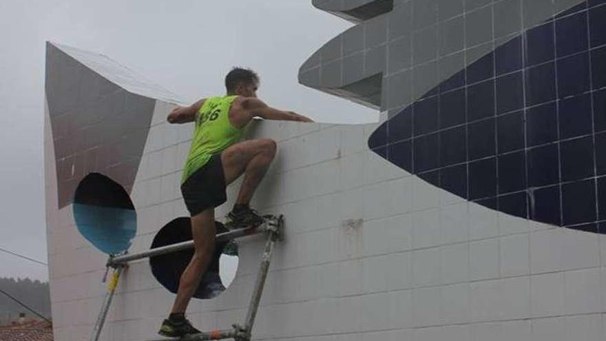 Uno de los participantes de la carrera trepa por la escultura &quot;Barco de Rubén Darío&quot;.