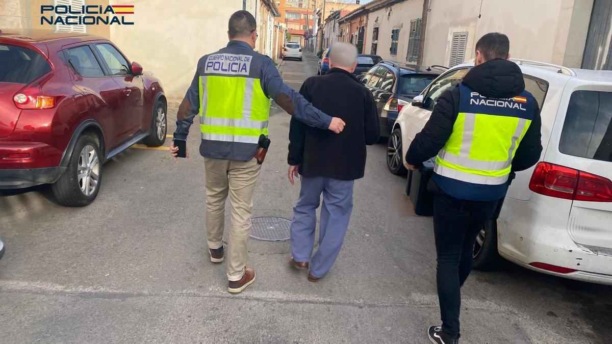 Dos agentes trasladan al detenido.