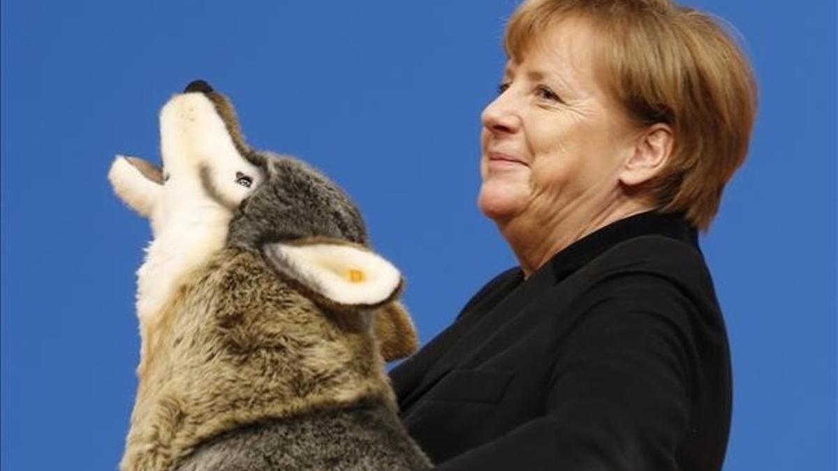 Angela Merkel, con un lobo de peluche con el que ha sido obsequiado en la convención de la CDU en Karlsruhe, este lunes.