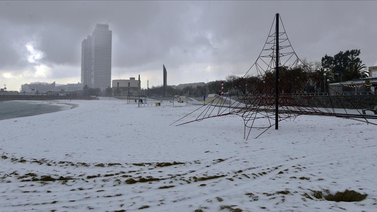 La playa de la Nova Icària se ha cubierto con un manto granulado de nieve, este mediodía.