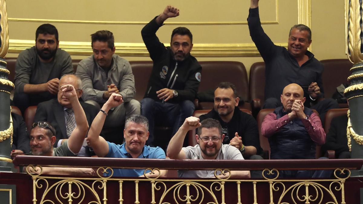 Un grupo de estibadores saludan desde la tribuna de invitados del Congreso donde se debatia el real decreto ley de reforma de la estiba.