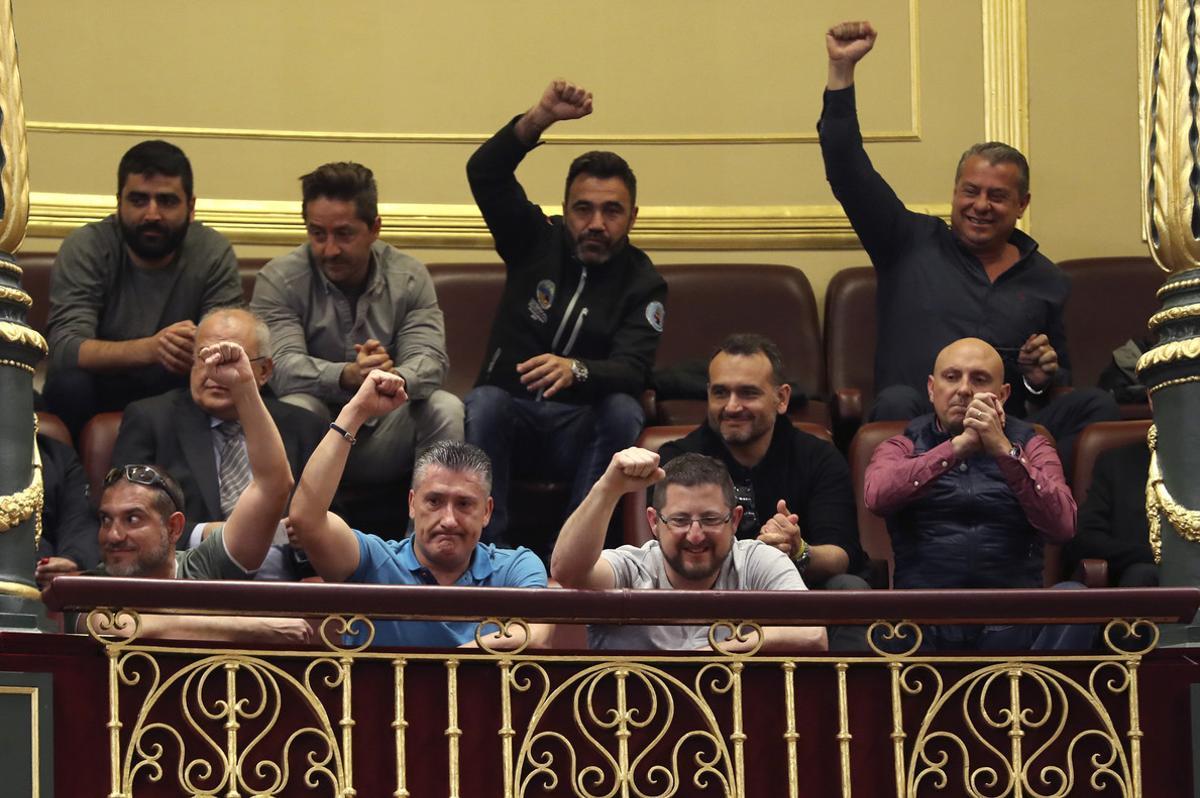 Un grupo de estibadores saludan desde la tribuna de invitados del Congreso donde hoy se debatia el real decreto ley de reforma de la estiba.