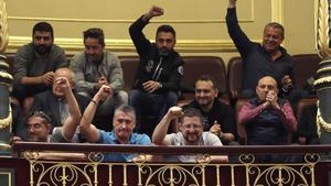 Un grupo de estibadores saludan desde la tribuna de invitados del Congreso donde hoy se debatia el real decreto ley de reforma de la estiba.