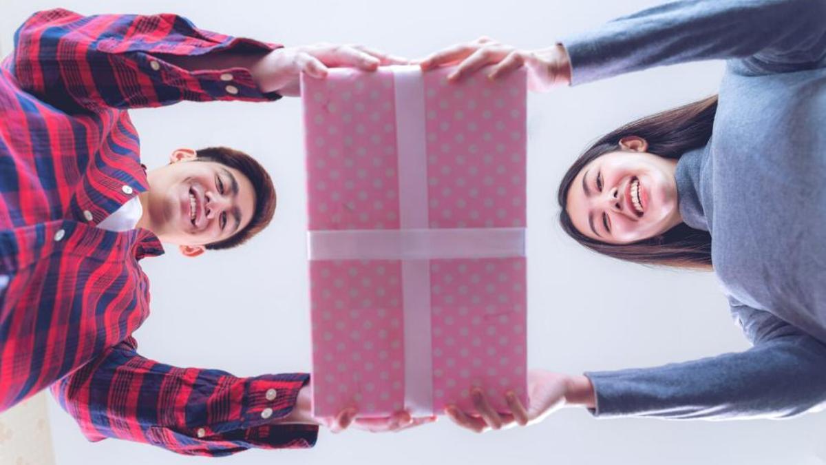Dos jóvenes sositenen un regalo