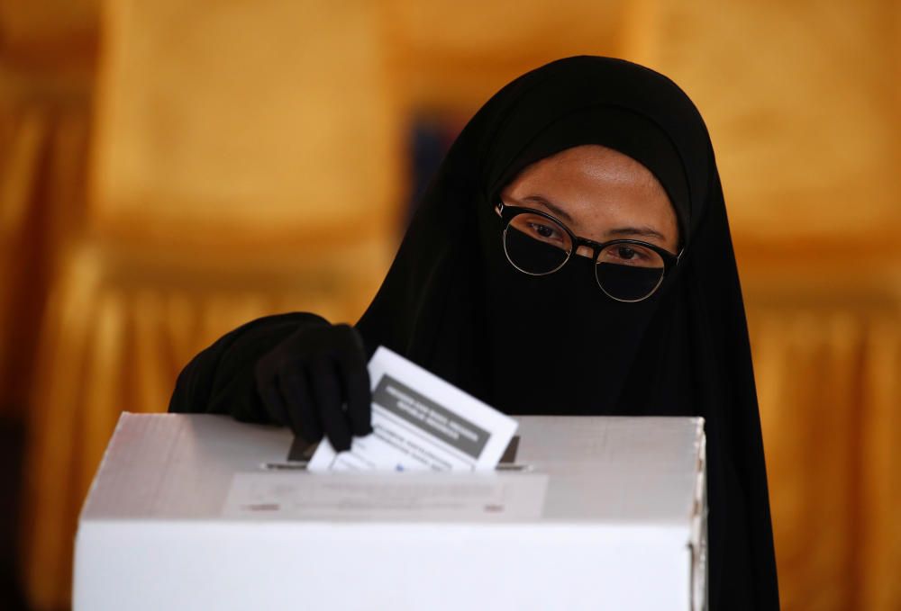 A voter casts her ballot during elections in ...