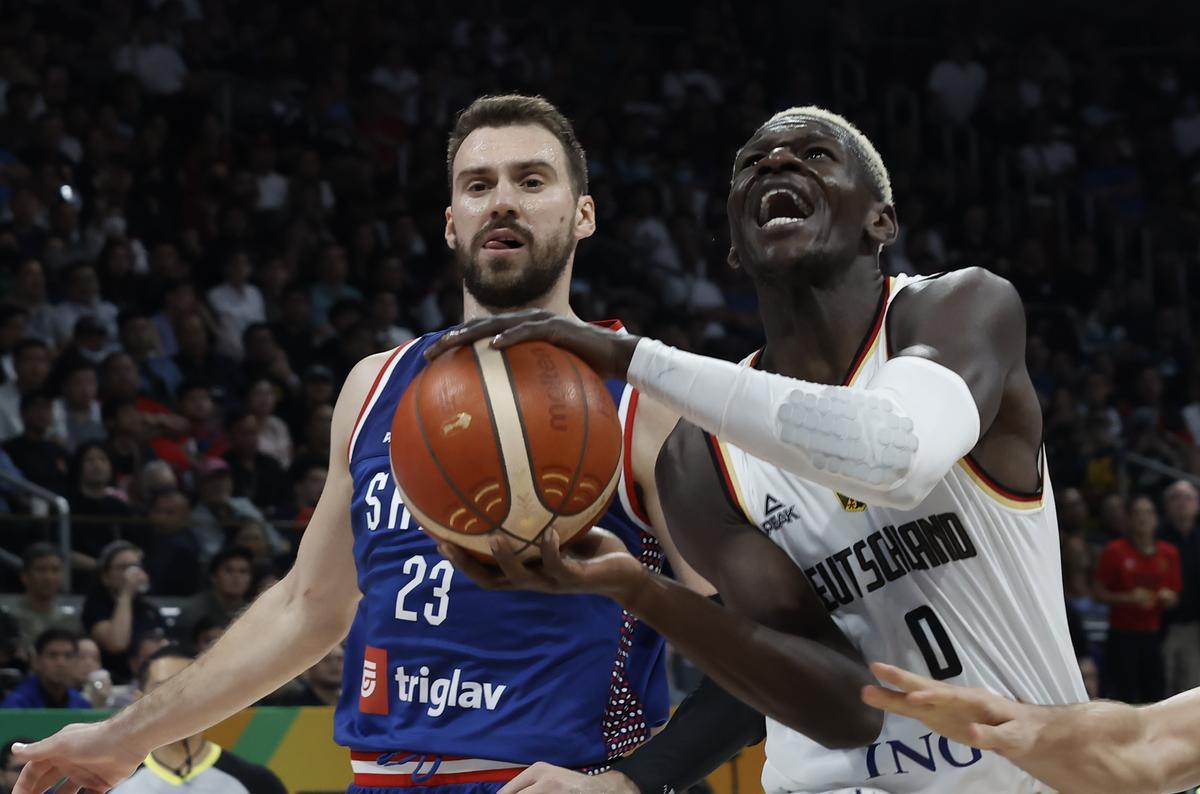Manila (Philippines), 10/09/2023.- Isaac Bonga of Germany (R) in action against Marko Guduric of Serbia during the FIBA Basketball World Cup 2023 final match between Serbia and Germany at the Mall of Asia in Manila, Philippines, 10 September 2023. (Baloncesto, Alemania, Filipinas) EFE/EPA/ROLEX DELA PENA