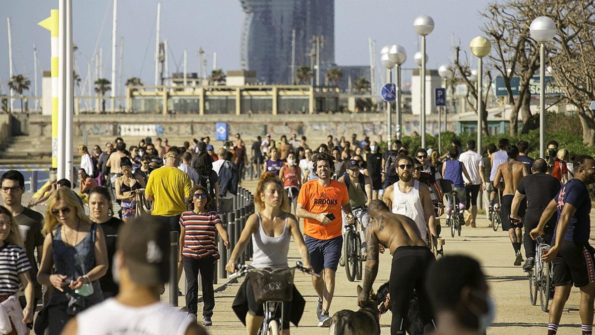 Decenas de personas pasean y hacen deporte en el paseo marítimo de Barcelona, muchas de ellas sin mascarilla, el 3 de mayo