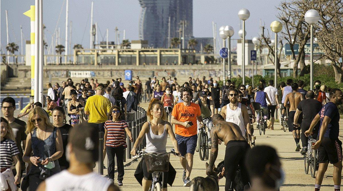 Decenas de personas pasean y hacen deporte en el paseo marítimo de Barcelona, muchas de ellas sin mascarilla, el 3 de mayo.