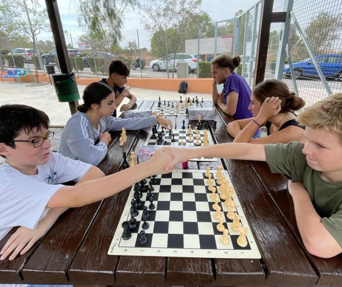 Alumnos jugando al ajedrez en el centro.