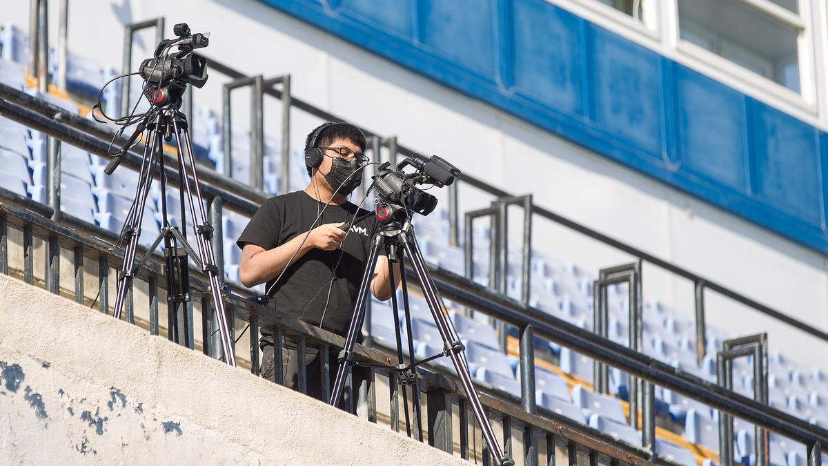 Un operario de cámara de Audiovisual Murcia toma imágenes de un partido del Hércules en el Rico Pérez.