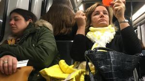 Una mujer se maquilla y otra duerme en un vagón del metro de Barcelona.