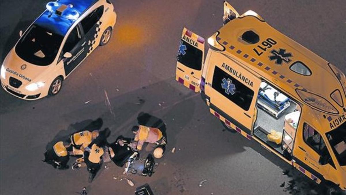 Miembros de los cuerpos de emergencia atienden a un motorista herido en el cruce de las calles Sardenya y Almogàvers, en octubre.