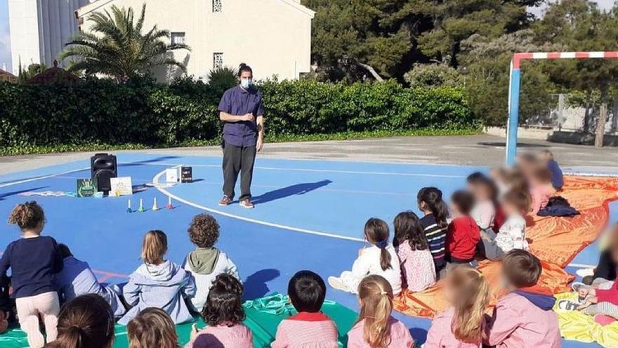 Los niños sentados sobre bandas de colores en el patio del colegio Voramar