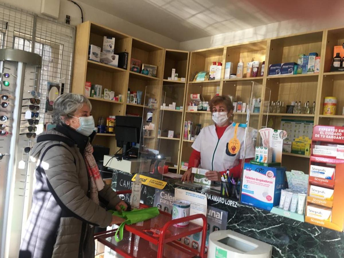 La farmacéutica Elena Amaro en su oficina de Requejo atiende a una cliente.