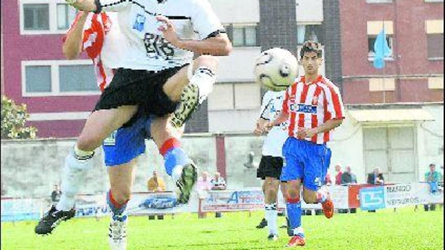 El caudalista Miguel intenta rematar un balón acosado por un defensor gijonés.