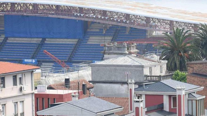 Bloque de pisos, chalés y zonas verdes privadas de Ciudad Jardín, con el estadio de Riazor al fondo.