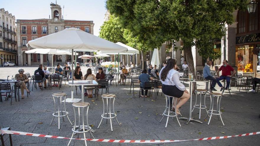 Varias personas sentadas en una terraza de la Plaza Mayor.